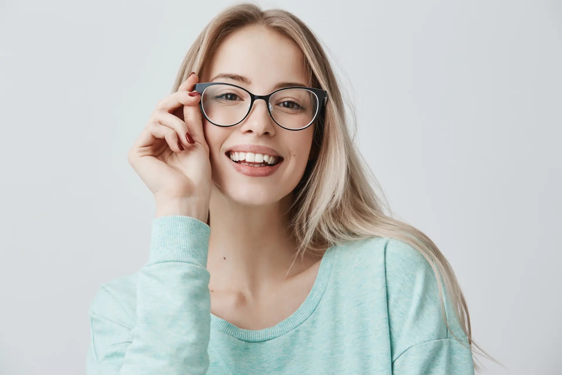 Mujer rubia con lentes sonriendo